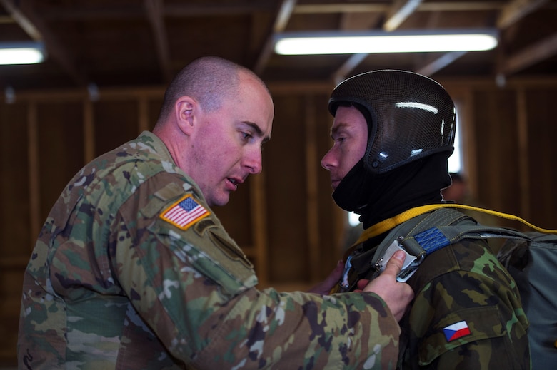 U.S. Army Staff Sgt. Nathaniel Bier, 301st Psychological Operations Company airborne specialist, left, inspects Czech Republic army warrant officer Miroslav Kloupar’s parachute ensemble during the 19th Annual Randy Oler Memorial Operation Toy Drop, Dec. 16, 2016, at Mackall Army Air Field, N.C. OTD is the world’s largest annual multinational airborne exercise which included 120 jumpmasters and 4,000 paratroopers during this year’s event. (U.S. Air Force photo by Airman 1st Class Greg Nash)   