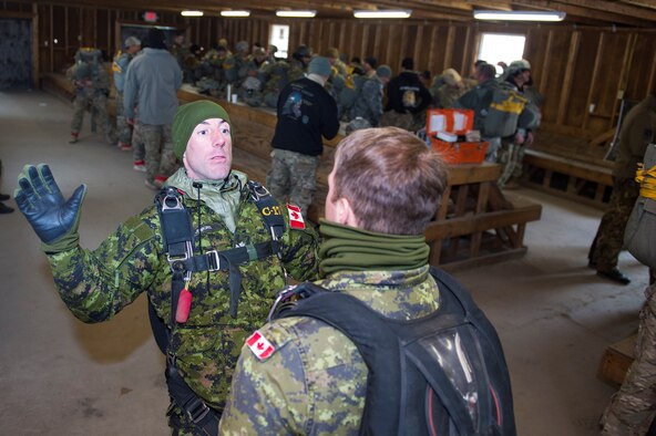 Sergeant Daniel Jenkins, Canadian army Advanced Warfare Center parachute instructor, shows Master Corporal Joey Miller, fellow CAAWC parachute instructor, exiting strategies to employ after flight during the 19th Annual Randy Oler Memorial Operation Toy Drop, Dec. 16, 2016, at Mackall Army Air Field, N.C. In addition to Canada, the nations of Botswana, Czech Republic, Germany, Italy, the Netherlands, Poland, and Singapore also participated. (U.S. Air Force photo by Airman 1st Class Greg Nash)   

