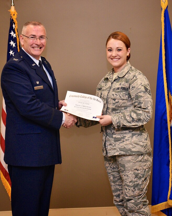 Col. Jonathan Philebaum, commander, 932nd Airlift Wing, presents a Community College of the Air Force graduation certificate to Staff Sgt. Kristin Cannon during a special weekend ceremony held on December 6, 2016 at the southern Illinois Air Force Reserve Command unit located at Scott Air Force Base, Ill.  (U.S. Air Force photo by Tech. Sgt. Christopher Parr)