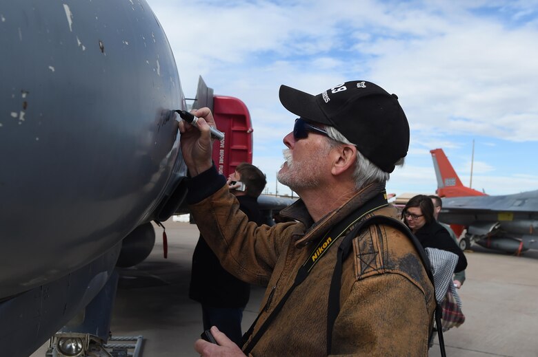 A veteran signs his name on a QF-4 Phantom during the “Pet the Jet” portion of the Phinal Phlight event commemoration at Holloman Air Force Base, N.M., on Dec. 21, 2016. The F-4 Phantom II entered the Air Force inventory in 1963, where it served as the primary fighter-bomber throughout the 1960’s and 1970’s. (U.S. Air Force photo by Staff Sgt. Eboni Prince)