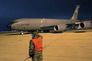A crew chief salutes as a KC-135 Stratotanker departs Selfridge Air National Guard Base for a deployment to Southwest Asia. Approximately 100 Airmen from Selfridge left on the deployment on the evening of Dec. 12. The Airmen will be deployed overseas through the holiday season and into early 2017. (U.S. Air National Guard photo by Tech. Sgt. Dan Heaton)