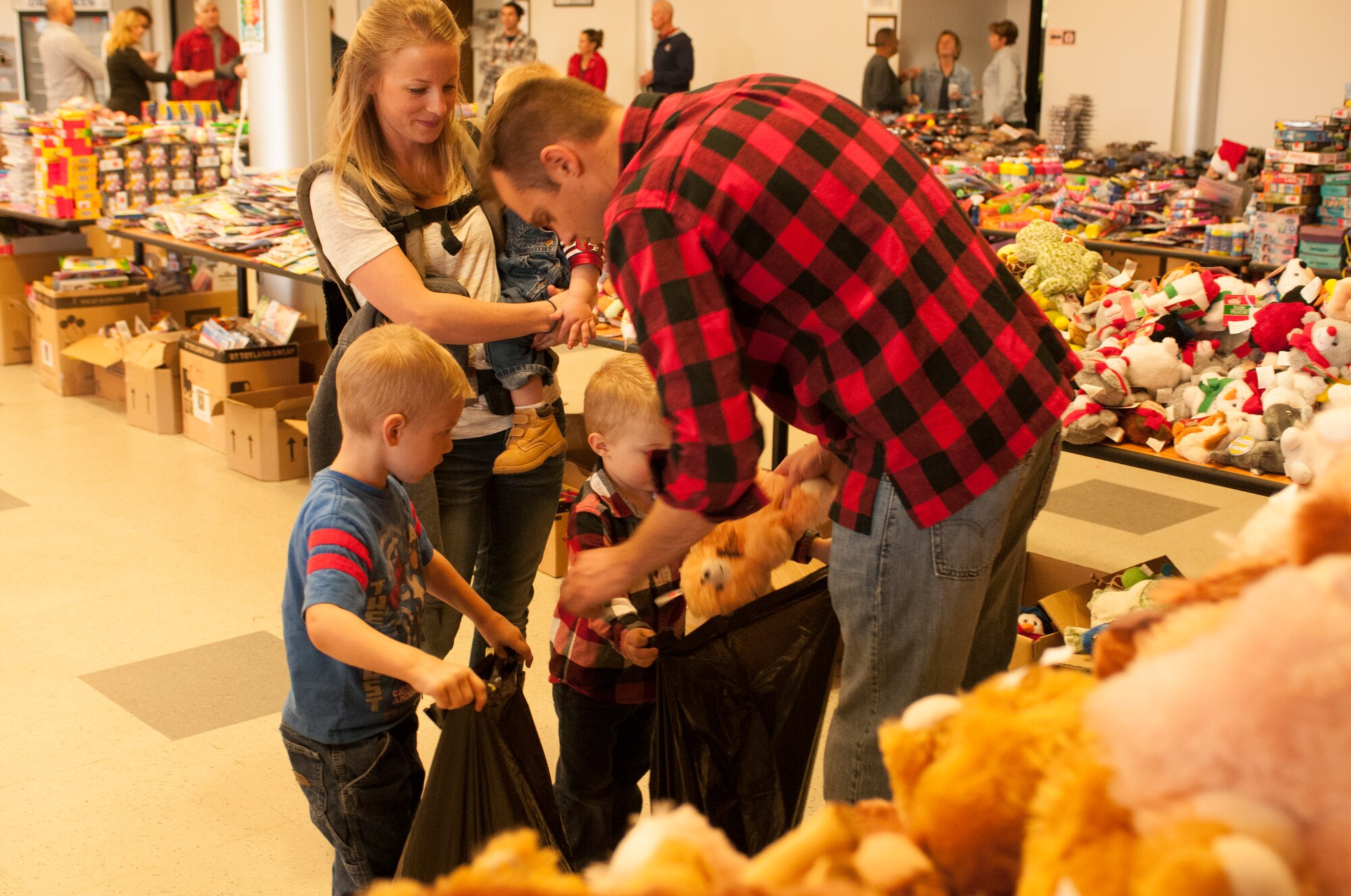 Senior Airman Gabriel Baker and his wife Ashley, help their son’s fill their bags with goodies during the ninth annual Holiday Open House held at the Arizona Air National Guard’s 162nd Wing located at Tucson International Airport, Saturday, Dec. 17. (U.S. Air National Guard photo by Staff Sgt. Micah Hill)