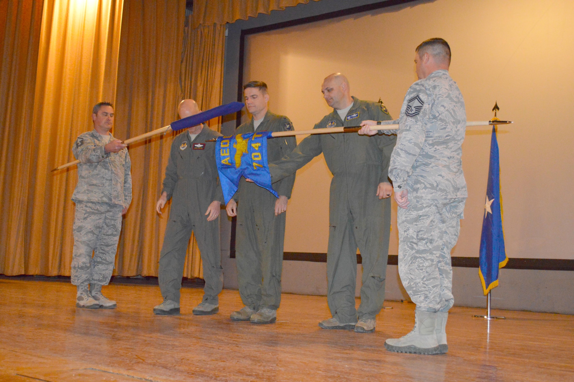 AEDC Commander Col. Rodney Todaro, center, observes while Col. Andrew L. Allen, (fourth from right), the 704th Test Group commander reveals the 704th Test Group guidon during a re-designation ceremony Dec. 6 at Holloman Air Force Base, New Mexico. The Test Group was previously the 96th Test Group under the 96th Test Wing, Eglin AFB, Florida. Also pictured left to right is flag bearer Master Sgt. Marc Berger, 96th Test Wing Commander Brig. Gen. Christopher Azzano and flag bearer Senior Master Sgt. Ian Hall. (U.S. Air Force photo/Tech. Sgt. Dejaye Herrera)