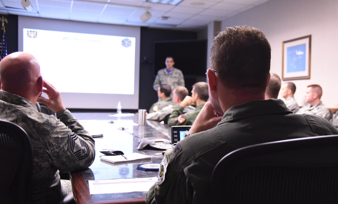 U.S. Air Force Col. Lance Wilkins, 53rd Weapon Evaluations Group commander, listens to Airmen briefing him in the 53rd WEG conference room Dec. 16, 2016. The initiative is meant to facilitate dialog between different squadrons within the 53rd WEG, who may or may not have had face-to-face interaction, to come up with plausible solutions for problems they may face. (U.S. Air Force photo by Senior Airman Solomon Cook/Released)