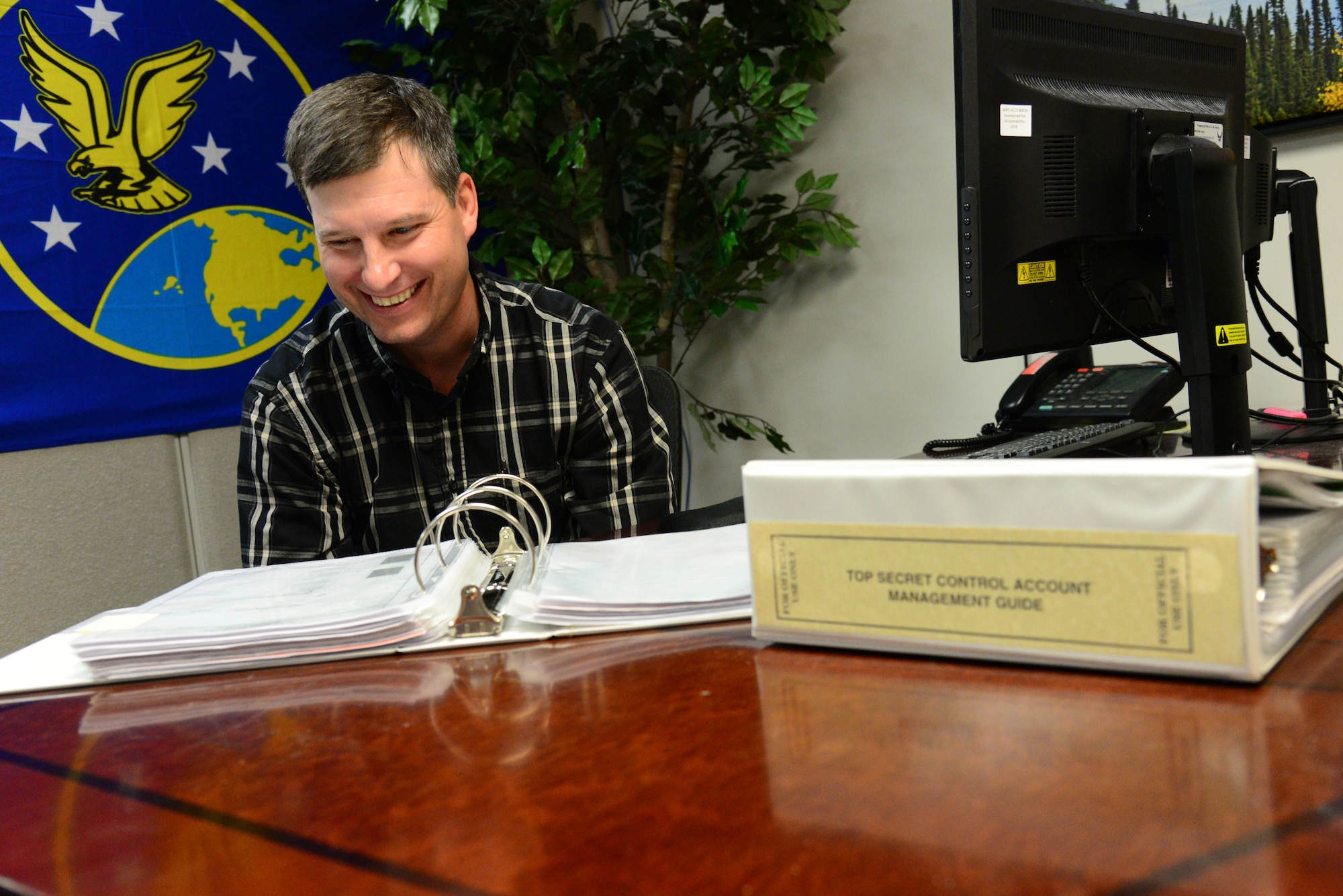 Kevin Younkin, 341st Operations Support Squadron security specialist, references one of his communications security guidance materials Nov. 2, 2016, at Malmstrom Air Force Base, Mont. Younkin works as a communications security manager responsible for several tasks which include maintaining accountability of classified materials and administering training to missileers on the proper handling of sensitive documents and information. (U.S. Air Force photo/Airman 1st Class Magen M. Reeves)