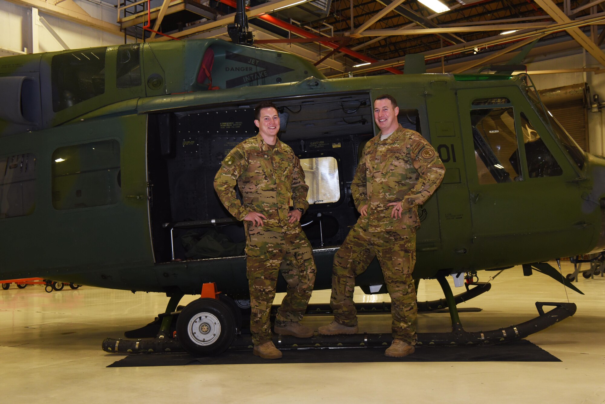 Tech. Sgt. Justin Nissen and Staff Sgt. Timothy Nissen, 37th Helicopter Squadron UH-1N helicopter flight engineers, pose next to a helicopter at F.E. Warren Air Force Base, Wyo., Dec. 12, 2016. After four years of trying, the brothers managed to get stationed together in the same unit. (U.S. Air Force photo by Airman 1st Class Breanna Carter)