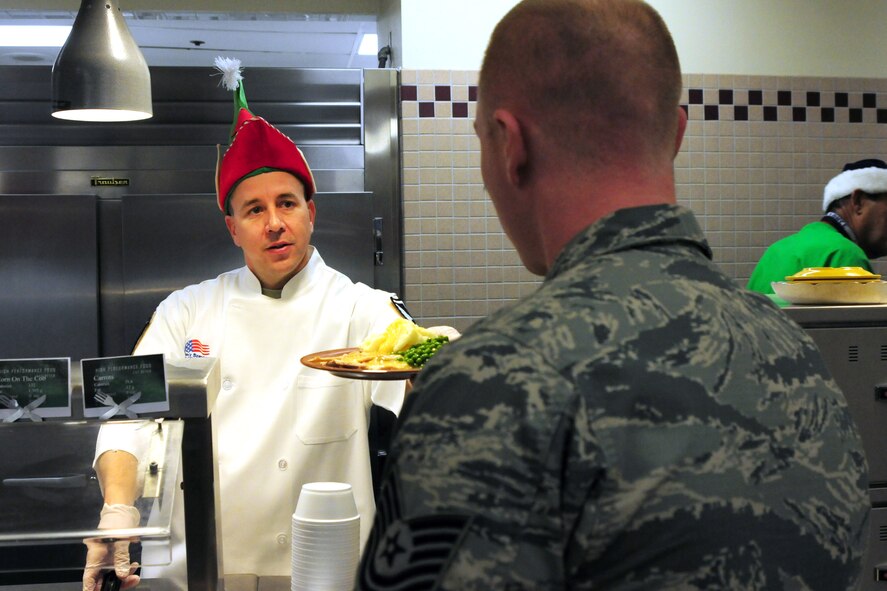 Master Sgt. Chad Peterson, 4th Space Operations Squadron first sergeant, serves lunch to Airmen during the leaders serving holiday meal event at Schriever Air Force Base, Colorado, Wednesday, Dec. 14, 2016.  The event helps link base leadership to Airmen.  (U.S. Air Force photo/Dennis Rogers.)