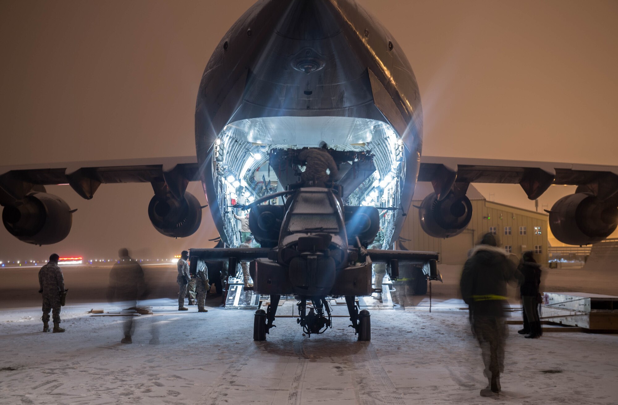 An AH-64 Apache helicopter from the 1st Attack Reconnaissance Battalion, 25th Combat Aviation Brigade, is loaded onto a C-17 Globemaster III aircraft from Joint Base Pearl Harbor-Hickam, Hawaii, Dec.18, 2016, at Eielson Air Force Base, Alaska. A contingency response team was sent to Eielson AFB to support the Army’s Rapid Alaska Airlift Week exercise. (U.S. Air Force photo by Staff Sgt. Robert Hicks)