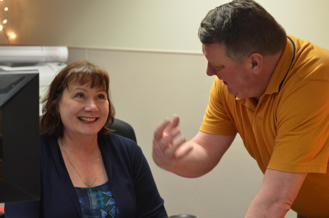 Trish Huizinga, the Defense Information School Civilian of the Quarter for the fourth quarter of fiscal 2016, shares a laugh with Will Smith on Dec. 14 at the school. The two have worked together since 2010 and are the academic directors of the school’s broadcast operations and maintenance department.