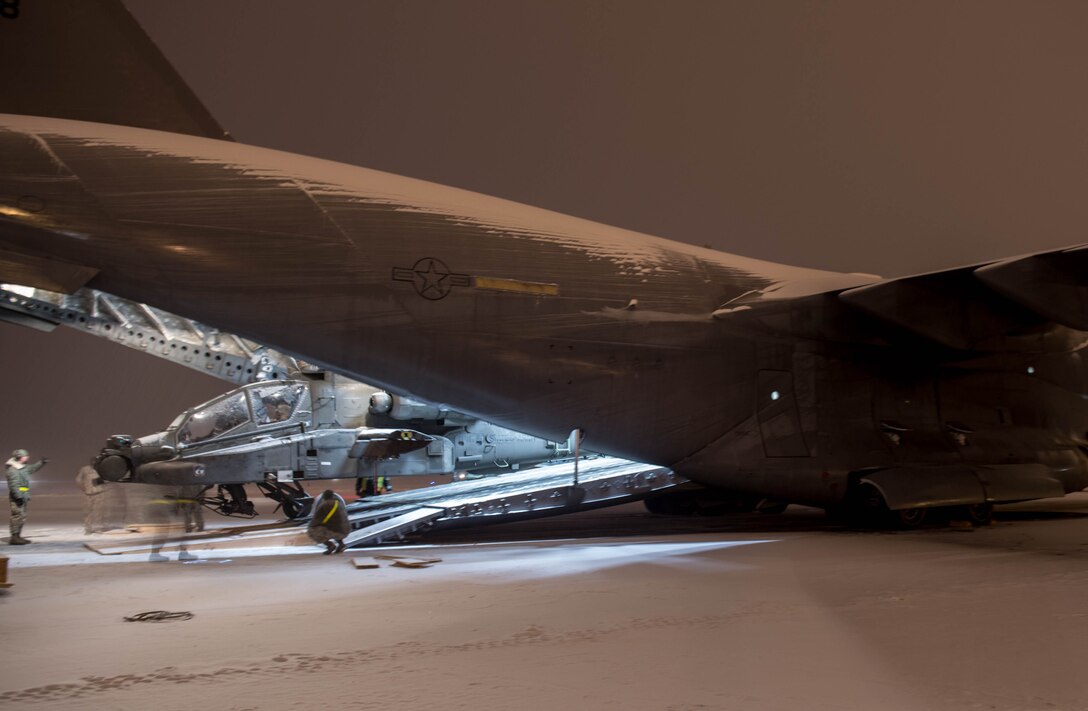 An AH-64 Apache helicopter from the 1st Attack Reconnaissance Battalion, 25th Combat Aviation Brigade, is loaded onto a C-17 Globemaster III aircraft from Joint Base Pearl Harbor-Hickam, Hawaii, Dec.18, 2016, at Eielson Air Force Base, Alaska. A contingency response team was sent to Eielson AFB to support the Army’s Rapid Alaska Airlift Week exercise. (U.S. Air Force photo by Staff Sgt. Robert Hicks)