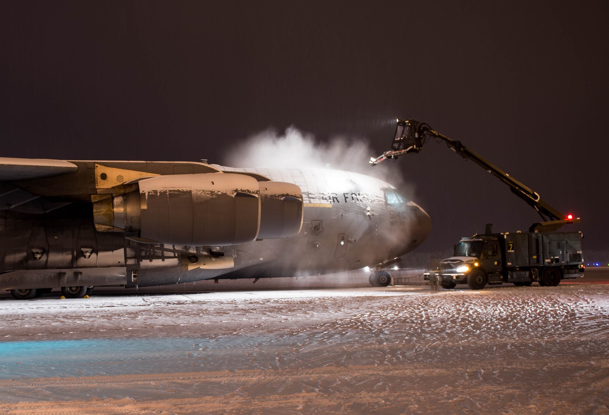 Maintainers from the 821st Contingency Response Group, deice a C-17 Globemaster III aircraft from Joint Base Pearl Harbor-Hickam, Hawaii, before taking off, Dec. 18, 2016, at Eielson Air Force Base, Alaska.  With temperatures well below freezing the deicer is used to provide protection of aircraft surfaces, engines and aircraft sensors from the elements. (U.S. Air Force photo by Staff Sgt. Robert Hicks) 