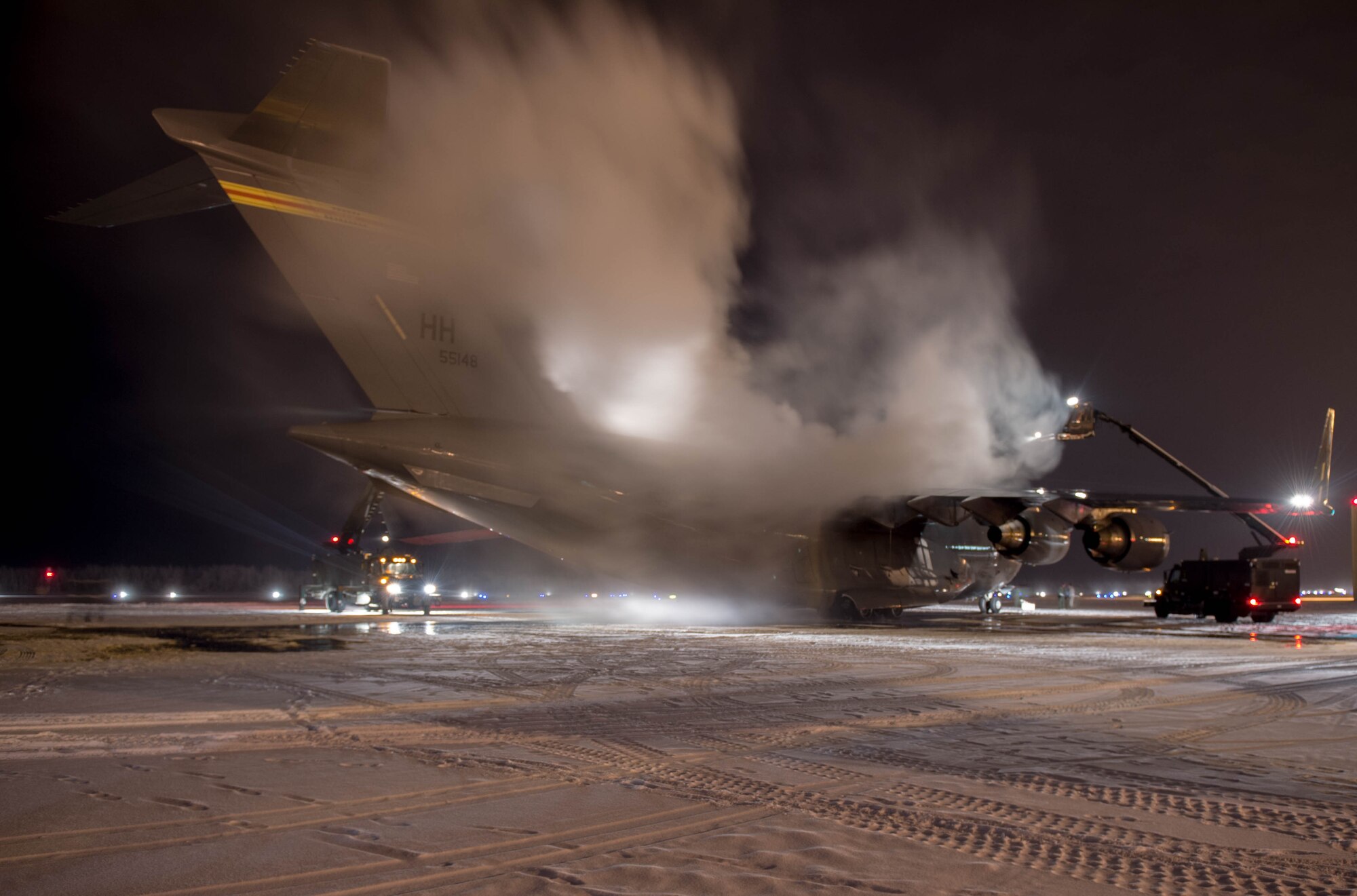 Maintainers from the 821st Contingency Response Group, deice a C-17 Globemaster III aircraft from Joint Base Pearl Harbor-Hickam, Hawaii, before taking off, Dec. 18, 2016, at Eielson Air Force Base, Alaska.  With temperatures well below freezing the deicer is used to provide protection of aircraft surfaces, engines and aircraft sensors from the elements. (U.S. Air Force photo by Staff Sgt. Robert Hicks) 