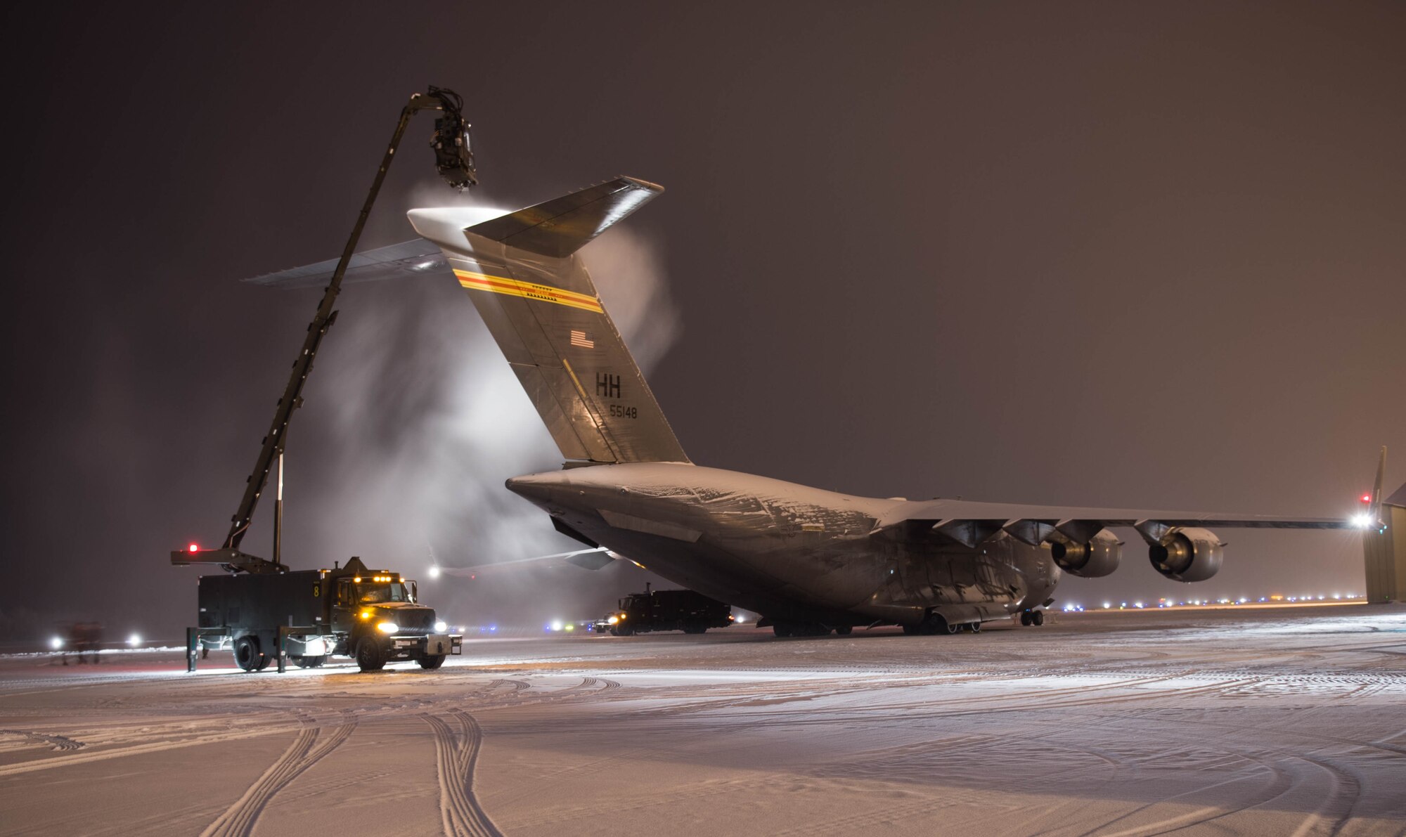 Maintainers from the 821st Contingency Response Group, uses a mobile truck mounted deicer to blow loose snow off a C-17 Globemaster III aircraft from Joint Base Pearl Harbor-Hickam, Hawaii, Dec.18, 2016, at Eielson Air Force Base, Alaska. A contingency response team was sent to Eielson AFB to support the Army’s Rapid Alaska Airlift Week exercise. (U.S. Air Force photo by Staff Sgt. Robert Hicks) 
