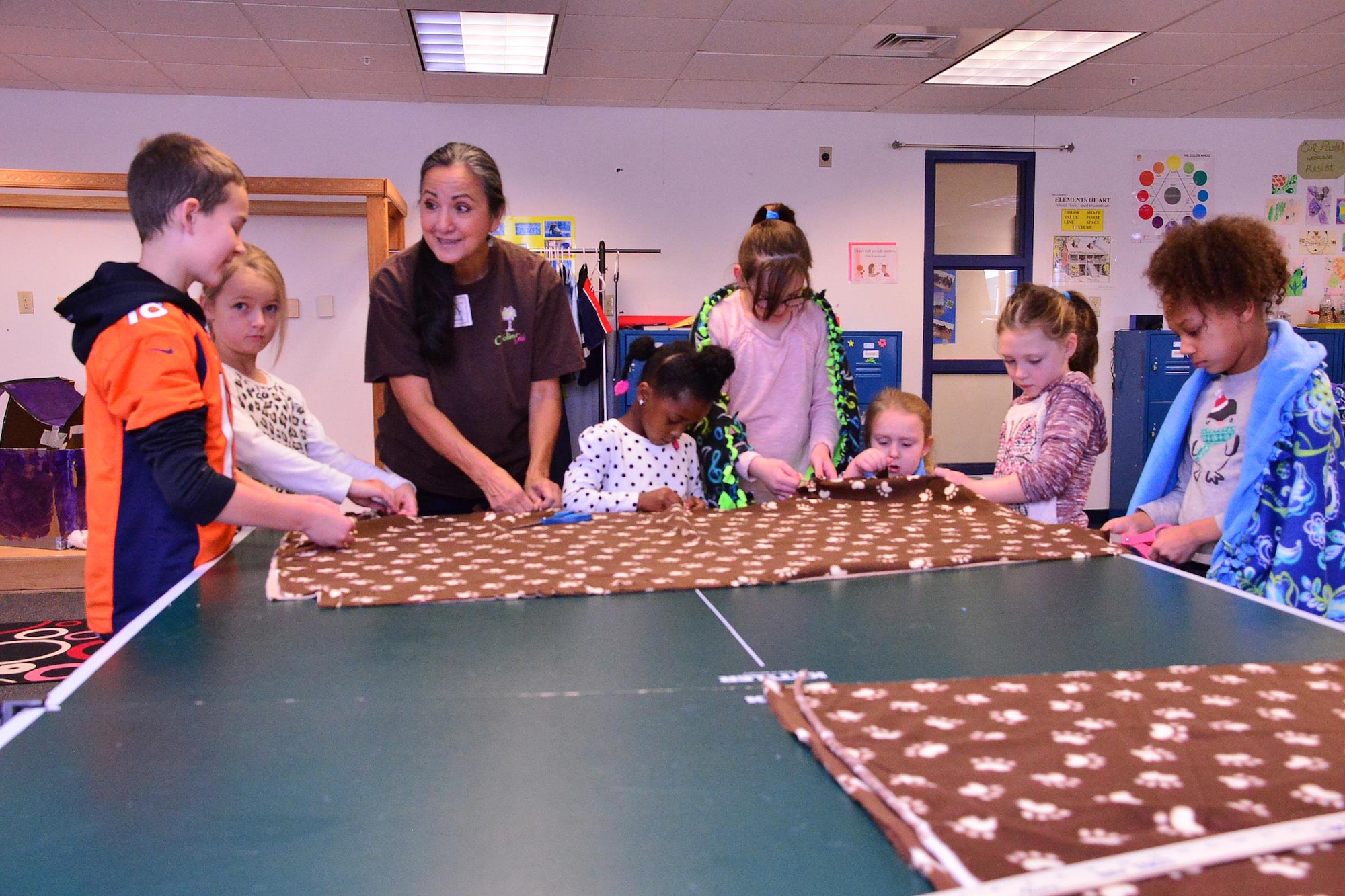 Leah Kennedy leads Schriever School Age Care program youth in a blanket-making activity at Schriever Air Force Base, Colorado, Wednesday, Dec. 21, 2016. The youth made approximately a dozen blankets to donate to local homeless shelters during the activity. (U.S. Air Force photo/Brian Hagberg)