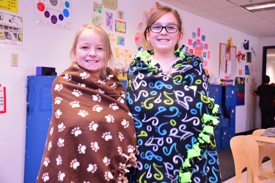 Arianna Carroll and Callie Hansen, Schriever School Age Care program youth, perform the “warm test” on the blankets they made during an activity at Schriever Air Force Base, Colorado, Wednesday, Dec. 21, 2016. The SAC youth spent two days making blankets to donate to local homeless shelters.  (U.S. Air Force photo/Brian Hagberg)