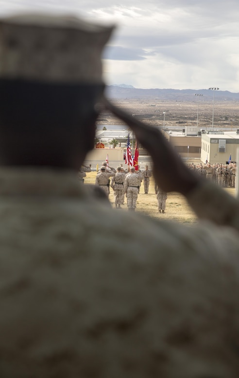 A Marine salutes the national and Marine Corps colors during 2nd Battalion,7th Marine Regiment’s change of command ceremony at Lance Cpl. Torrey L. Gray Field aboard Marine Corps Air Ground Combat Center Twentynine Palms, Calif., Dec. 15, 2016. Lt. Col. Christopher T. Steele relinquished command of 2/7 to Lt. Col Jonathan Q. Kenney. ( Official Marine Corps Photo by Cpl. Julio McGraw/Released)