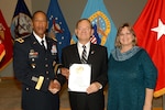 Army Brig. Gen. Charles Hamilton, DLA Troop Support commander, presents Russ Brooks, Subsistence field representative, with a certificate of retirement during a ceremony Dec. 15. Brooks was accompanied by his wife Denise, whom he thanked for standing beside him during his career.