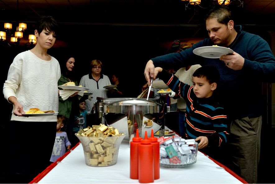 Team Shaw members serve themselves food at a Breakfast with Santa event at Shaw Air Force Base, S.C., Dec. 17, 2016. During the event, families had the opportunity to eat breakfast and make holiday crafts before Santa Claus arrived. (U.S. Air Force photo by Airman 1st Class Destinee Sweeney)