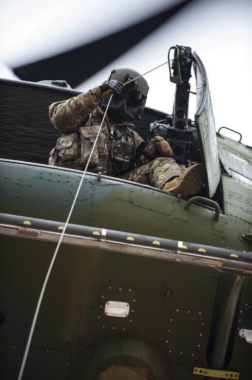 Staff Sgt. Travis Akerson, 37th Helicopter Squadron flight engineer, guides down a hoist to a training target 50 feet below the helicopter during search and rescue training at F.E. Warren Air Force Base, Wyo., Dec. 16. 2016. The 37th HS assists local civilian law enforcement with with SAR operations and airlift medical evacuations in Wyoming, Colorado and Nebraska. (U.S. Air Force photo by Staff Sgt. Christopher Ruano)