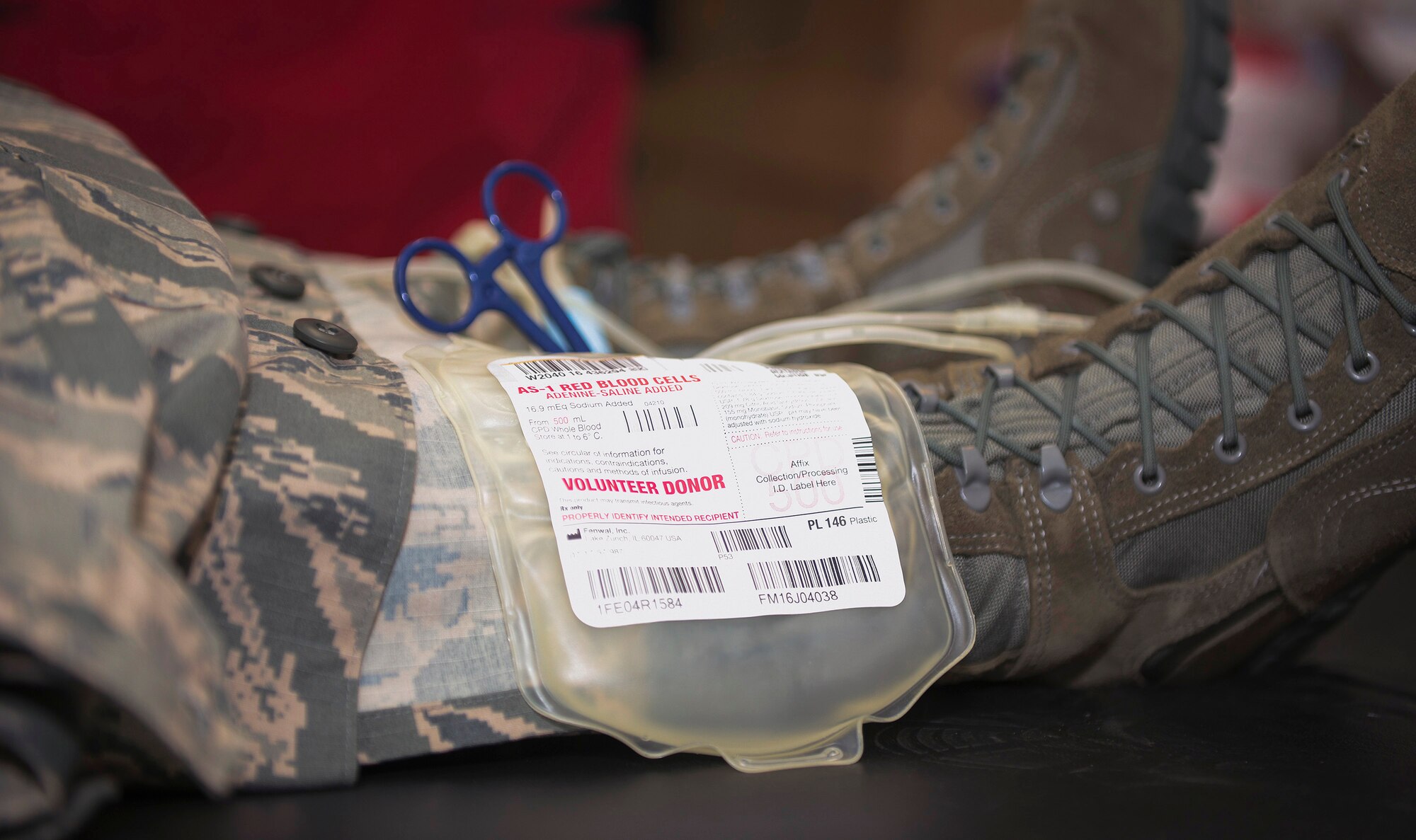 A blood donation bag rests on an Airman’s leg at an American Red Cross blood drive at the 182nd Airlift Wing in Peoria, Ill., Dec. 14, 2016. The wing’s company grade officers council hosted the event as a way for unit members to give back to their communities. (U.S. Air National Guard photo by Tech. Sgt. Lealan Buehrer)