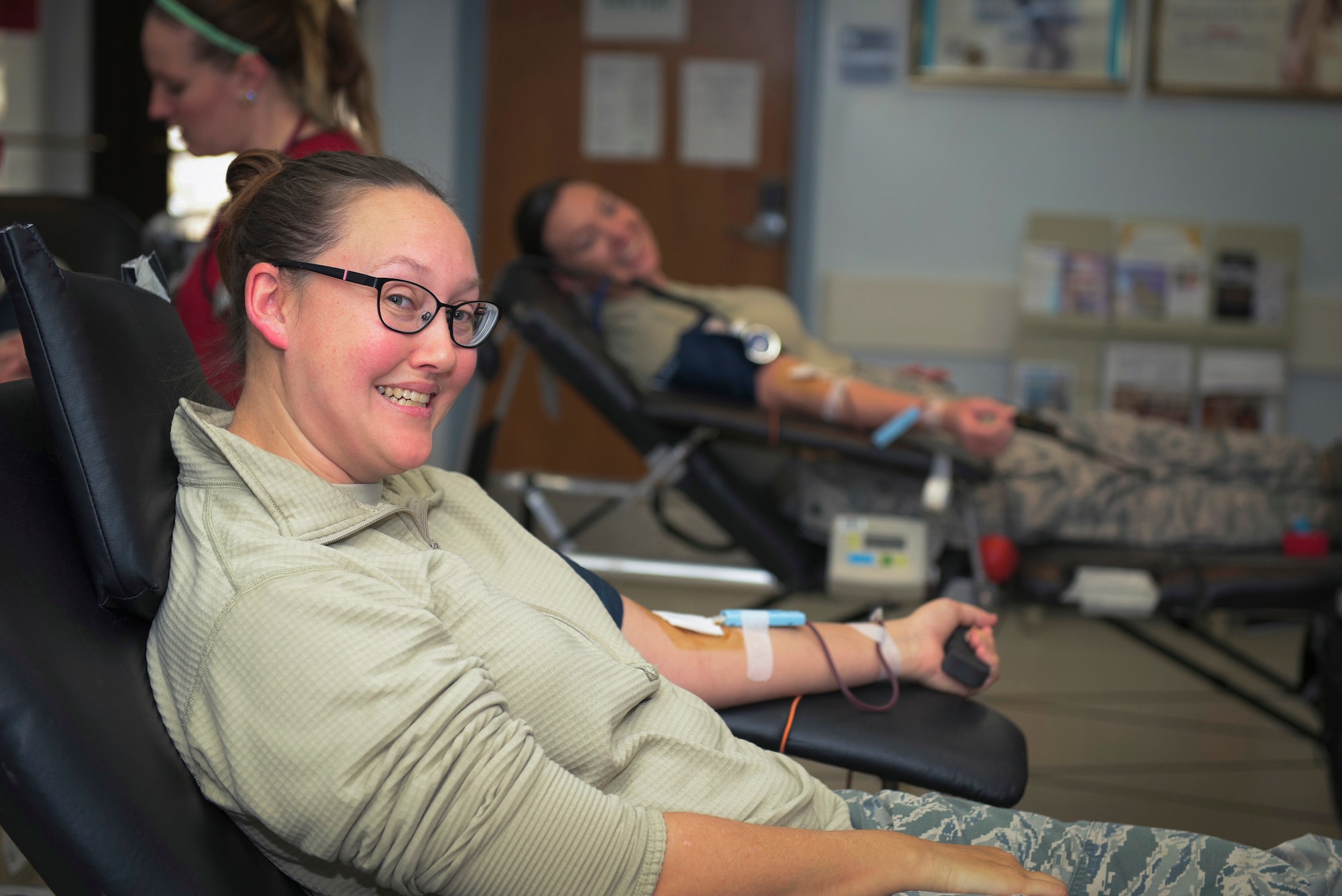 U.S. Air Force Master Sgt. Sara Corteville, a command post superintendent with the 182nd Airlift Wing, Illinois Air National Guard, and Tech. Sgt. Dawn Tavenner, background, the chief of information protection with the 182nd Security Forces Squadron, donate blood at an American Red Cross blood drive in Peoria, Ill., Dec. 14, 2016. The wing’s company grade officers council hosted the event as a way for unit members to give back to their communities. (U.S. Air National Guard photo by Tech. Sgt. Lealan Buehrer)