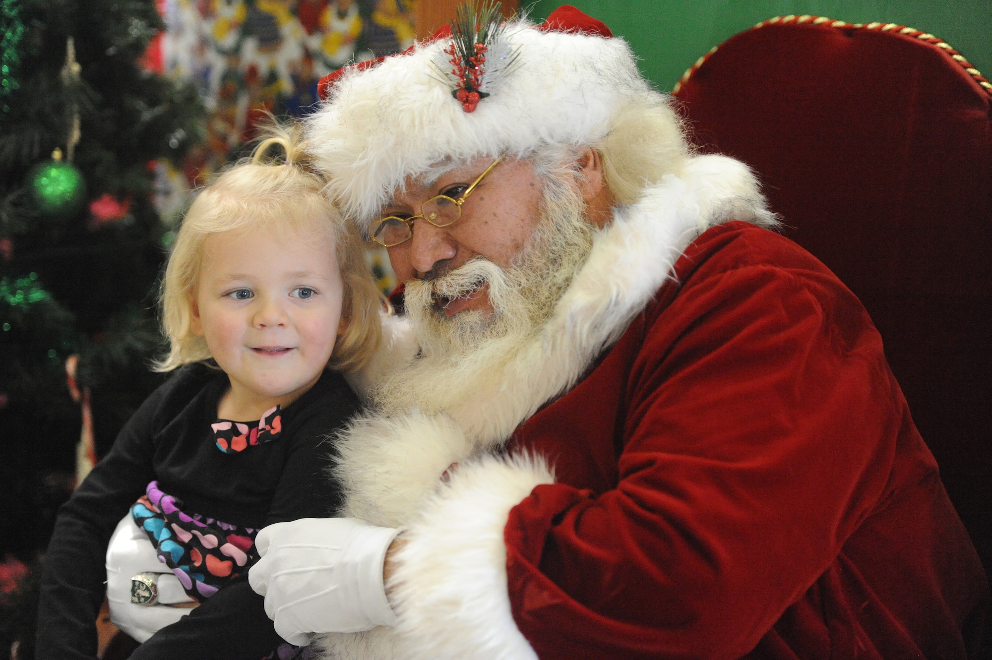 Santa Claus visits with a young child at Operation Holiday Cheer, one of Kirtland's biggest charitable events of the year. The event, hosted annually by the Kirtland Air Force Base Fire Department, delivered more than 800 new, high-quality toys to children Dec. 14.  More than 1,700 members of the community received a full holiday meal, with turkey, enchiladas, posole, mashed potatoes and desserts. 