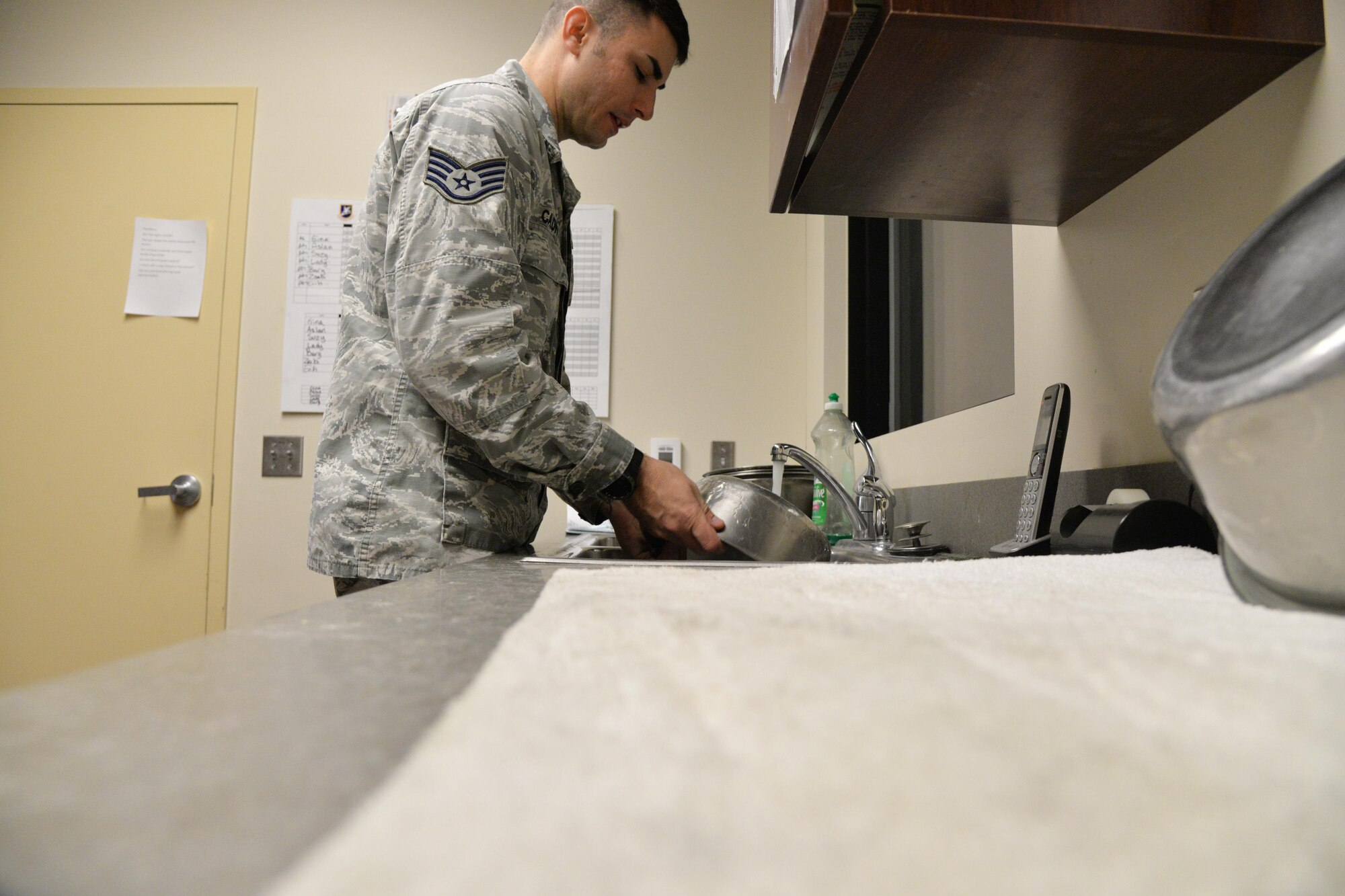 Staff Sgt. Jordan Caldwell, 341st Security Forces Squadron military working dog handler, washes dog feeding containers Dec. 20, 2016, at Malmstrom Air Force Base, Mont. Caldwell arrives to work at 4:30 a.m. to feed seven K-9s and clean their kennels each morning. (U.S. Air Force photo/Airman 1st Class Daniel Brosam)