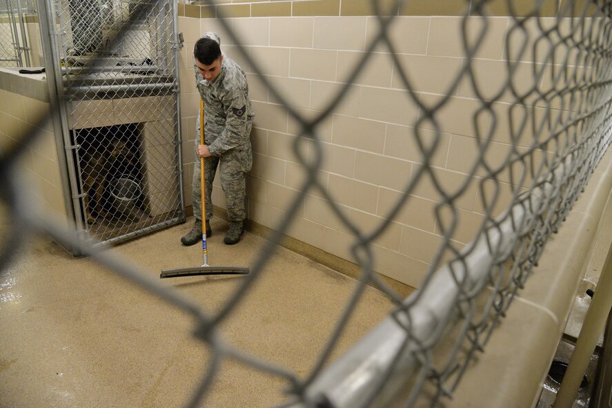 Staff Sgt. Jordan Caldwell, 341st Security Forces Squadron military working dog handler, cleans a dog kennel Dec. 20, 2016, at Malmstrom Air Force Base, Mont. Each morning and throughout the day, Caldwell cleans seven kennels as part of his daily duties. (U.S. Air Force photo/Airman 1st Class Daniel Brosam)