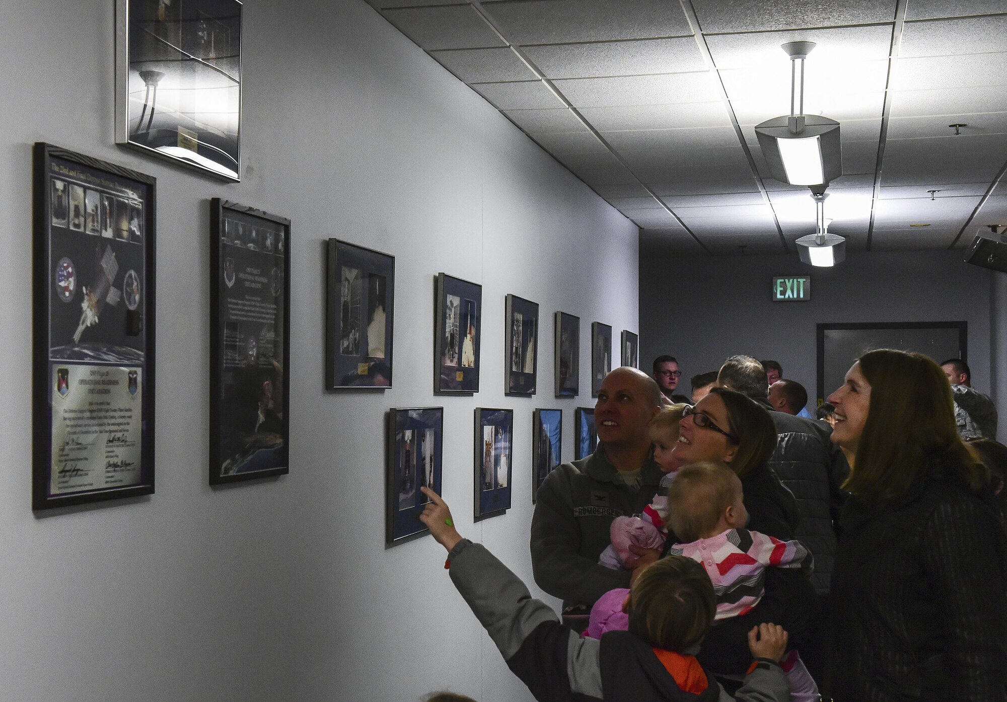 Col. Scott Romberger, 460th Space Wing vice commander, explains to his family the Defense Support Program satellites while pointing out the one he worked on when he was a lieutenant during at Team Buckley Spouse and Family Day at the Mission Control Center on Buckley AFB, Colo., Dec. 22, 2016. The event consisted of families given access to see the 460th Space Wing mission up close, with demonstrations from the operators, Defenders, and firefighters. (U.S. Air Force photo by Tech. Sgt. Nicholas Rau/Released)