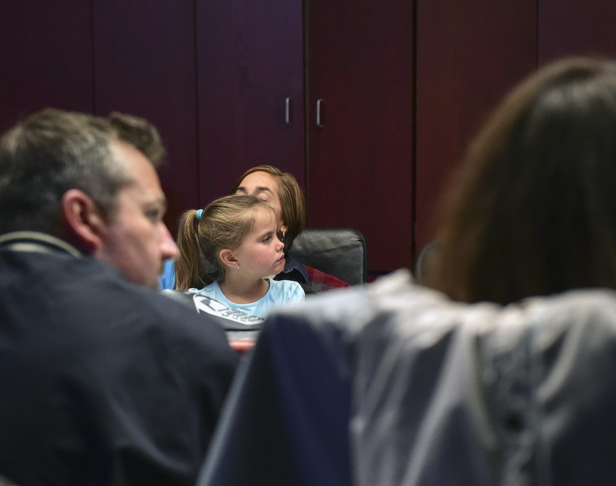 Addison listens intently while Col. David Miller Jr., 460th Space Wing commander, explains how missile warning satellites orbit the earth during at Team Buckley Spouse and Family Day at the Mission Control Center on Buckley AFB, Colo., Dec. 22, 2016. The event consisted of families given access to see the 460th Space Wing mission up close, with demonstrations from the operators, Defenders, and firefighters. (U.S. Air Force photo by Tech. Sgt. Nicholas Rau/Released)