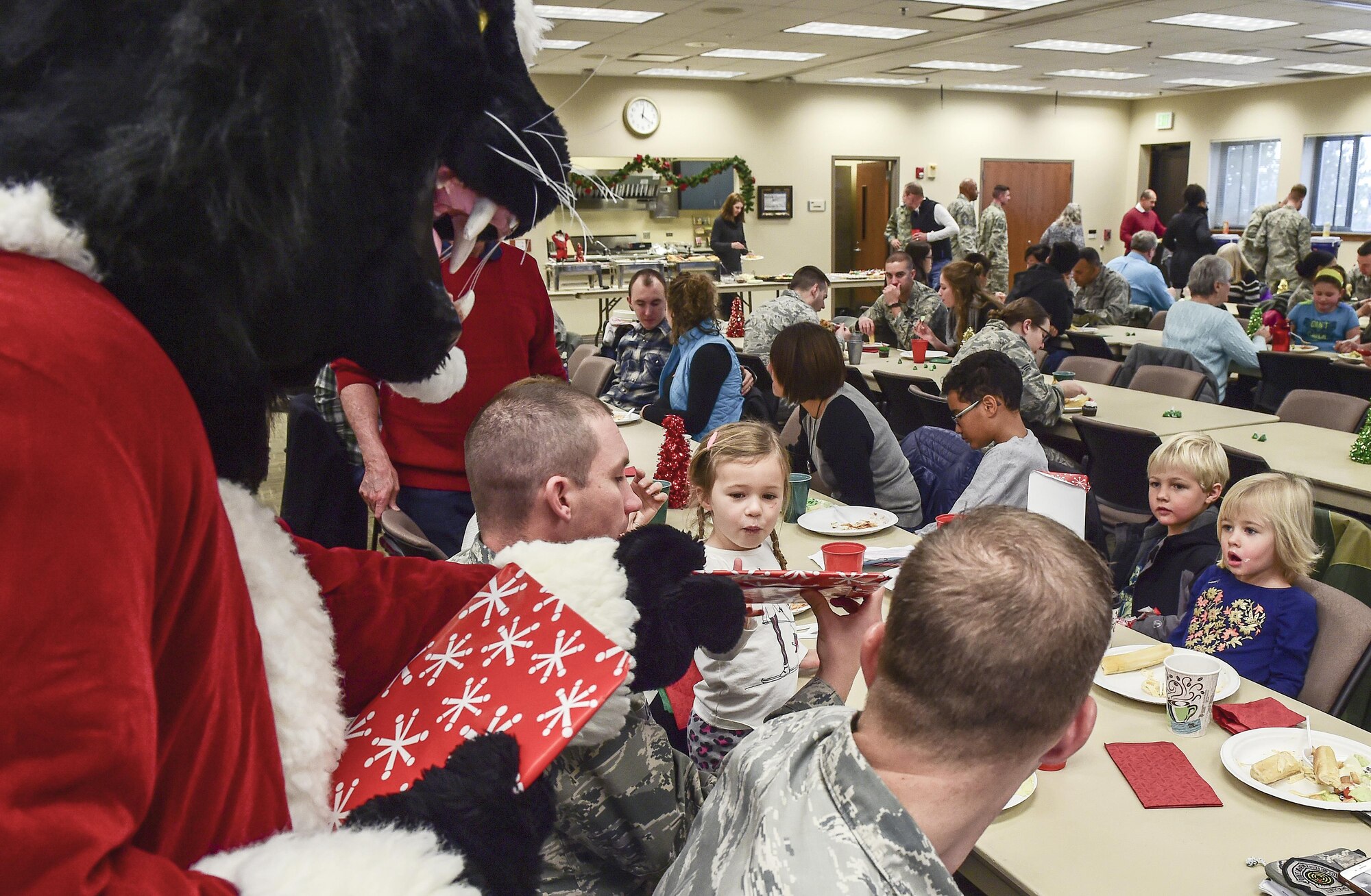 A child receives a surprise gift from Buck Lee, six-star general and Buckley Air Force Base mascot, as others look on in amazement during Team Buckley Spouse and Family Day at the Base Chapel on Buckley AFB, Colo., Dec. 22, 2016. The event consisted of families given access to see the 460th Space Wing mission up close, with demonstrations from the operators, Defenders, and firefighters. (U.S. Air Force photo by Tech. Sgt. Nicholas Rau/Released)