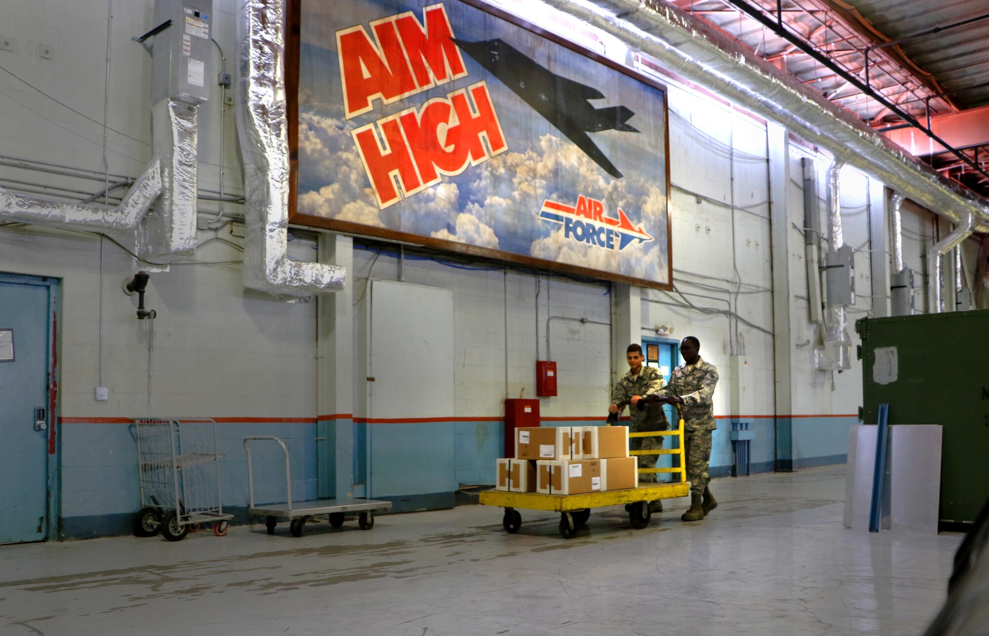Senior Airmen Thomas Perez and William Lawson, 927th Logistics Readiness Squadron material managers push a cart on Dec. 20, 2016 at MacDill Air Force Base, FL. Perez and Lawson were in during the week to assist the 927 LRS with clearing storage space. (U.S. Air Force photo by Senior Airman Xavier Lockley)