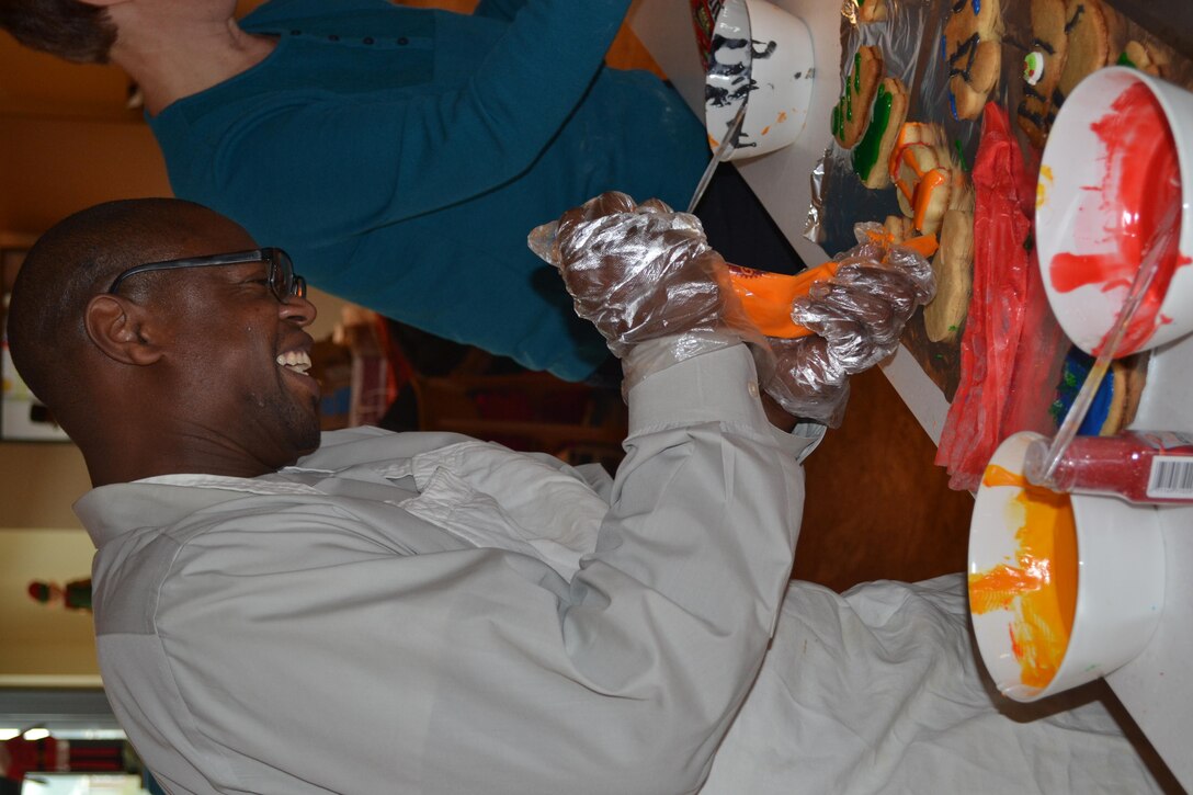 George Gray adds holiday cheer to sugar cookies his team baked  at the USO Warrior and Family Center, Dec. 21, 2016.