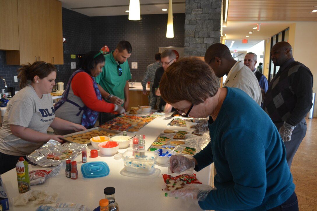 From left: Courtney Gutteridge, Dorothy Russell, Mike Johnson, Bill Farmer, George Gray, Dennis Ross, Derrick Washington and Judy Durnin (right foreground), of DLA Logistics Operations' Disposal Policy and Compliance Division, bake cookies at the USO Metro Warrior and Family Center, Fort Belvoir, Virginia, Dec. 21, 2016.