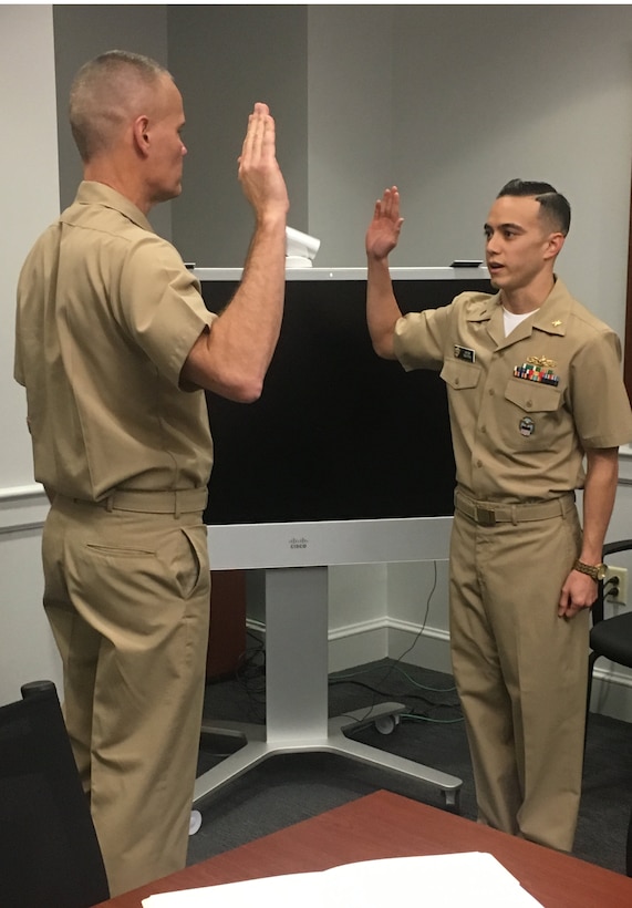 Navy Capt. Harry Thetford, commander of DLA Distribution Norfolk, Va., administers the officer’s oath of office prior to Navy Lt. j.g. Jacob Nguyen being promoted to lieutenant.