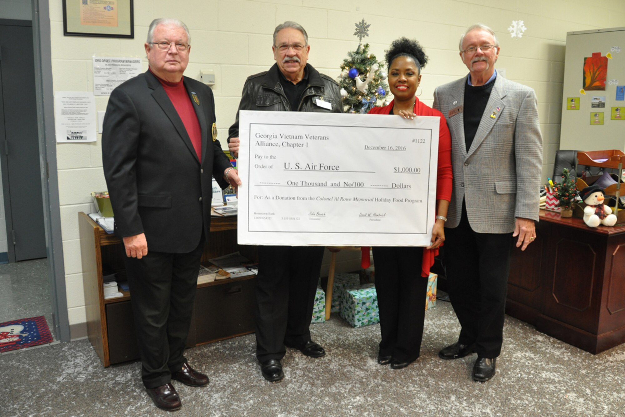 John Bevich, David Hambrick and Bob Humphries of the Georgia Vietnam Veterans Alliance present Angela Pedersen, 94th Airlift Wing Airman and Family Readiness director, $1000 to purchase gift cards for military families in need. The alliance has made donations to military families for the past 16 years. (U.S. Air Force photo/James Branch)