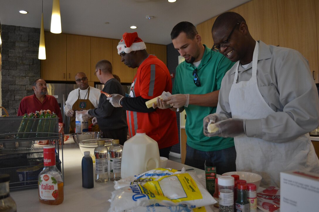 From left: Tony Acosta, Reggie Burks, Bill Farmer, James Reed, Mike Johnson and George Gray prepare the ingredients for cookies the team made from scratch Dec. 21, 2016, at the USO Warrior and Family Center, Fort Belvoir, Virginia.