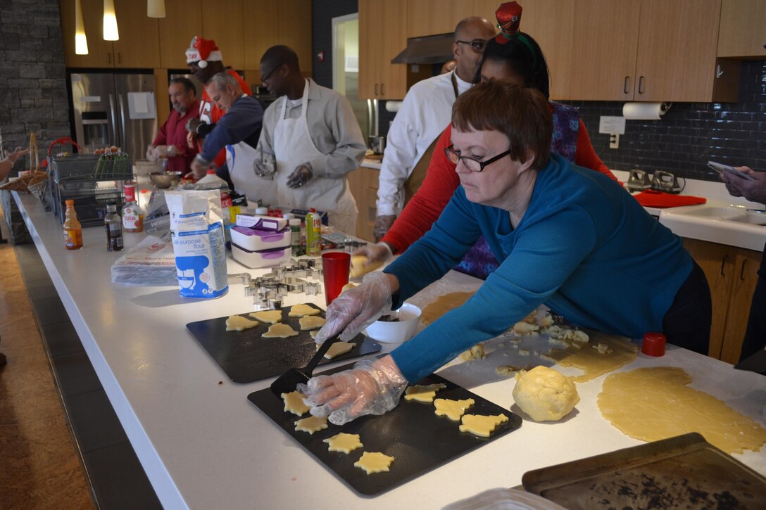 Judy Durnin places newly formed cookies on a baking sheet, Dec. 21, 2016, at the USO Warrior and Family Center, Fort Belvoir, Virginia.