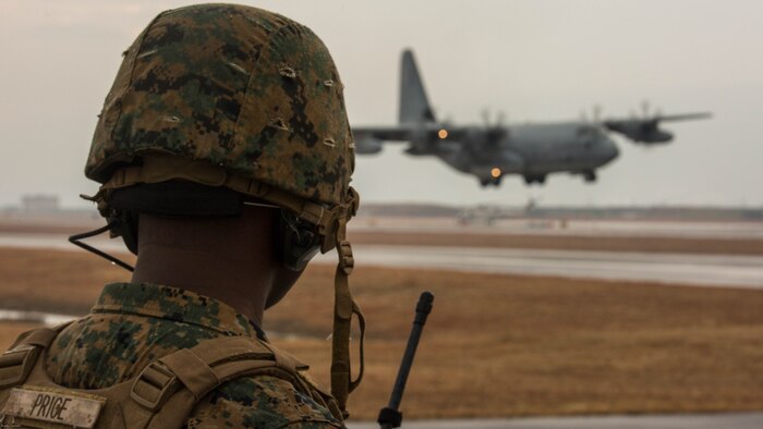 U.S. Marine Corps Staff Sgt. George Price, an Marine Air Traffic Control Mobile Team instructor with Marine Air Control Squadron  4 Detachment Bravo, directs a KC-130J Hercules with Marine Aerial Refueler Transport Squadron 152 during a landing as part of aircraft landing zone training at Marine Corps Air Station Iwakuni, Japan, Dec. 21, 2016. The training allows the Marines to gain experience, practice constructing an expeditionary airfield, and complete training and readiness requirements. The MMT Marines conduct this training every three to six months to refine the Marines’ skills, keeping them ready for expeditionary operations while in a garrison environment. 