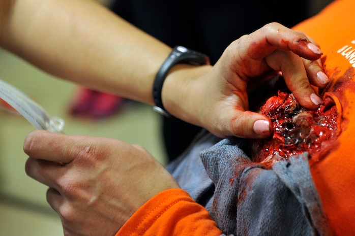 Master Sgt Caroline Bunce, 628th Aerospace Medicine Squadron dental hygienist, completes a moulage application simulating a sucking chest wound. Bunce applied the moulage to Tech Sgt. Aaron De L'etoile, 628th Medical Support Squadron medical readiness NCOIC, in preparation for a mass casualty exercise at Joint Base Charleston, South Carolina, Dec. 21, 2016. The exercise evaluated the response capabilities of medical group personnel and the coordination and response of Trident Medical Center, one of the major medical facilities in the local community. 
