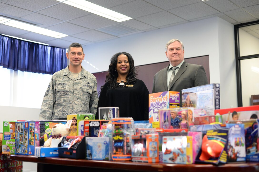 Stephanie Parker, center, director of Fort Lee Army Community Service, accepts a donation of more than 100 toys from the Defense Contract Management Agency. The holiday gifts were delivered Dec. 20 by Air Force Chief Master Sgt. Michael Mitchell, DCMA senior enlisted advisor (left); Richard Fanney, Technical Directorate executive director (right); and Army Lt. Col. Kenneth Darnall, executive officer. (DCMA photo by Stephen Hickok)
