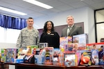 Stephanie Parker, center, director of Fort Lee Army Community Service, accepts a donation of more than 100 toys from the Defense Contract Management Agency. The holiday gifts were delivered Dec. 20 by Air Force Chief Master Sgt. Michael Mitchell, DCMA senior enlisted advisor (left); Richard Fanney, Technical Directorate executive director (right); and Army Lt. Col. Kenneth Darnall, executive officer. (DCMA photo by Stephen Hickok)