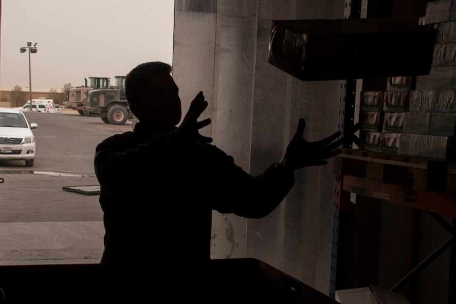 Senior Airman Gavin Payton, a 386th Expeditionary Force Support Squadron rations team member, catches a box in a storeroom Dec. 22, 2016 at an undisclosed location in Southwest Asia. The 386th EFSS Airmen worked quickly to ensure the tri-walls of holiday food items would be ready in time to ship to forward-deployed service members before Christmas. (U.S. Air Force photo/Senior Airman Andrew Park)