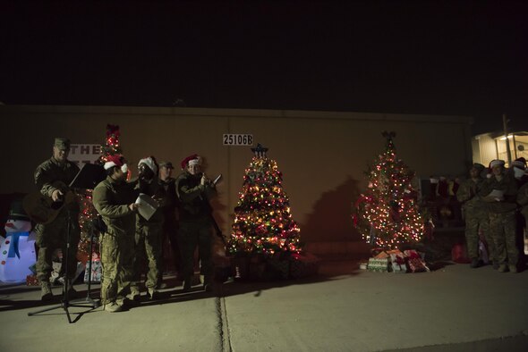 Carolers from the 455th Air Expeditionary Wing cheer after the lighting of the Christmas trees at Bagram Airfield, Afghanistan, Dec. 15, 2016. The Christmas tree lighting ceremony also featured caroling, a bonfire, s’mores and appearances by Santa Claus, Buddy the Elf, Rudolph, and the Grinch. (U.S. Air Force photo by Staff Sgt. Katherine Spessa)