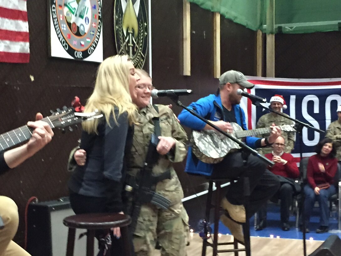 A 1st Infantry Division soldier sings "Tough" with Kellie Pickler during a Dec. 24, 2016, Christmas Eve USO show at Union 3 in Baghdad, Iraq. Marine Corps Gen. Joe Dunford, the chairman of the Joint Chiefs of Staff, brought the show to Iraq to thank service members for their efforts and sacrifices during the holidays. DoD photo by Jim Garamone