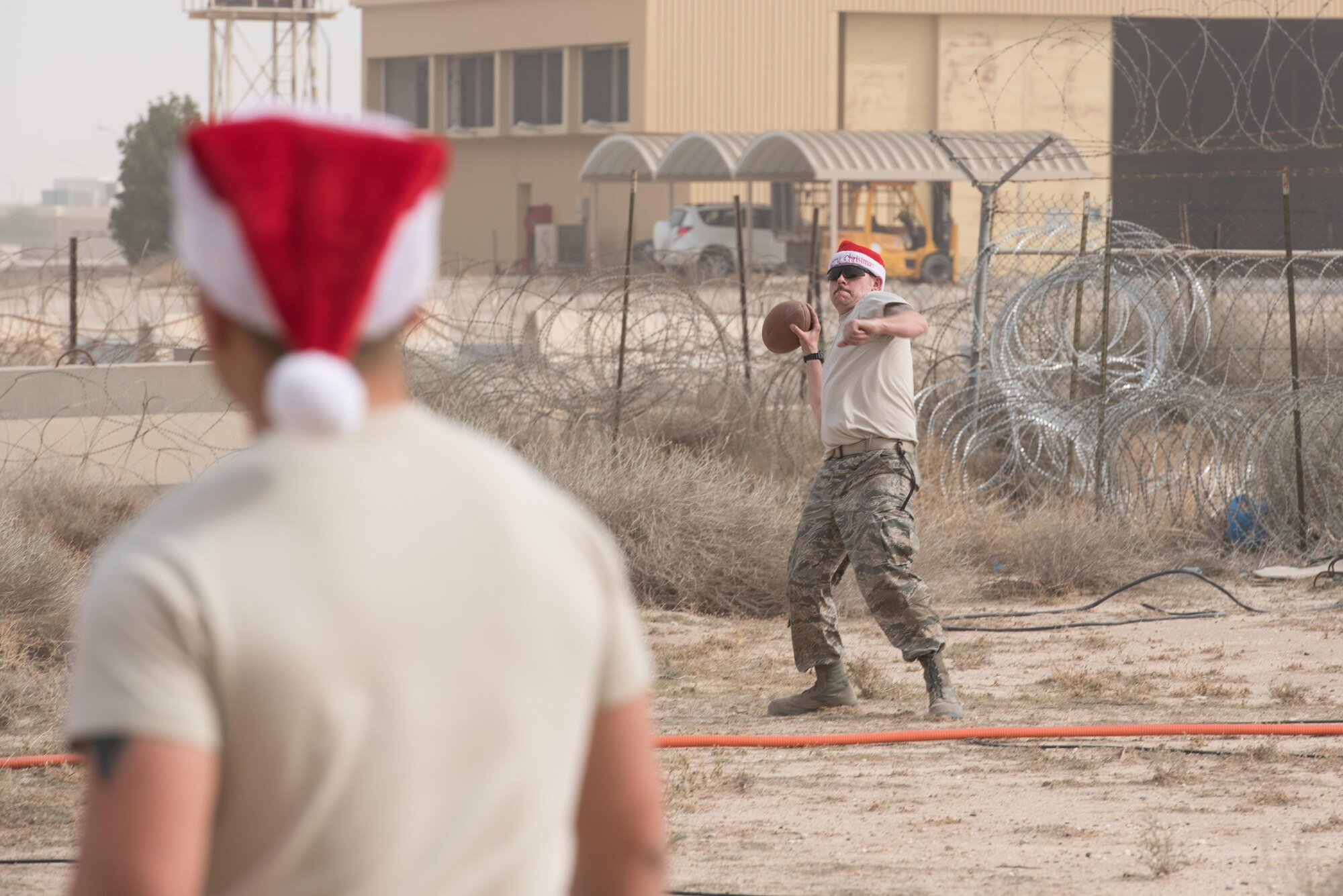 Senior Airman Cameron Stommel, 407th Expeditionary Maintenance Squadron, throws a football during a little down time while deployed to an undisclosed location in Southwest Asia, Dec. 25, 2016. The deployed there were working on Christmas Day to enable combat air operations in support of Operation Inherent Resolve.  (U.S. Air Force photo/Master Sgt. Benjamin Wilson)