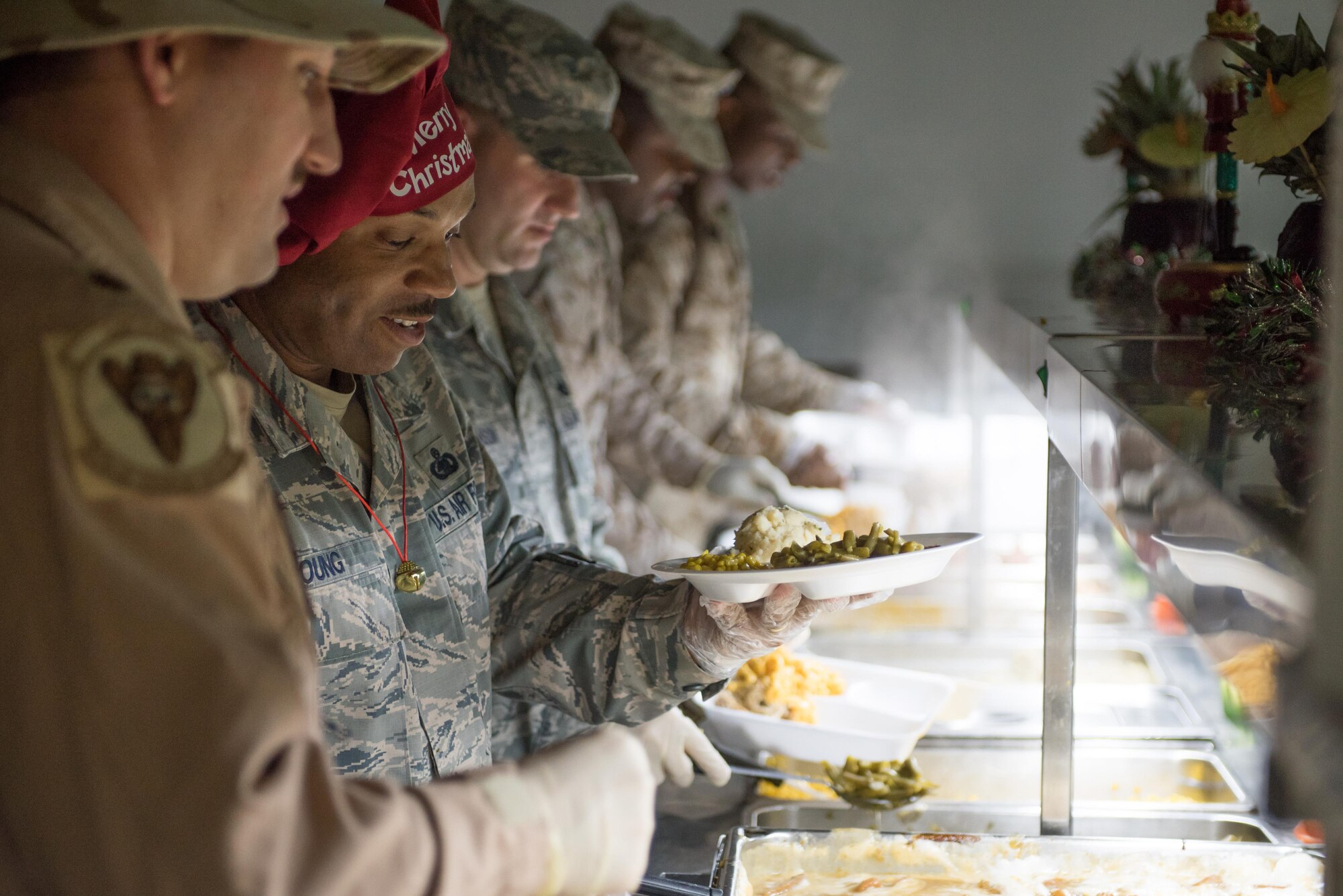 Leadership from the 407th Air Expeditionary Group serve a Christmas meal to the Airmen and Marines deployed under their charge at an undisclosed location in Southwest Asia, Dec. 25, 2016. The service members deployed here are supporting Operation Inherent Resolve.  (U.S. Air Force photo/Master Sgt. Benjamin Wilson)