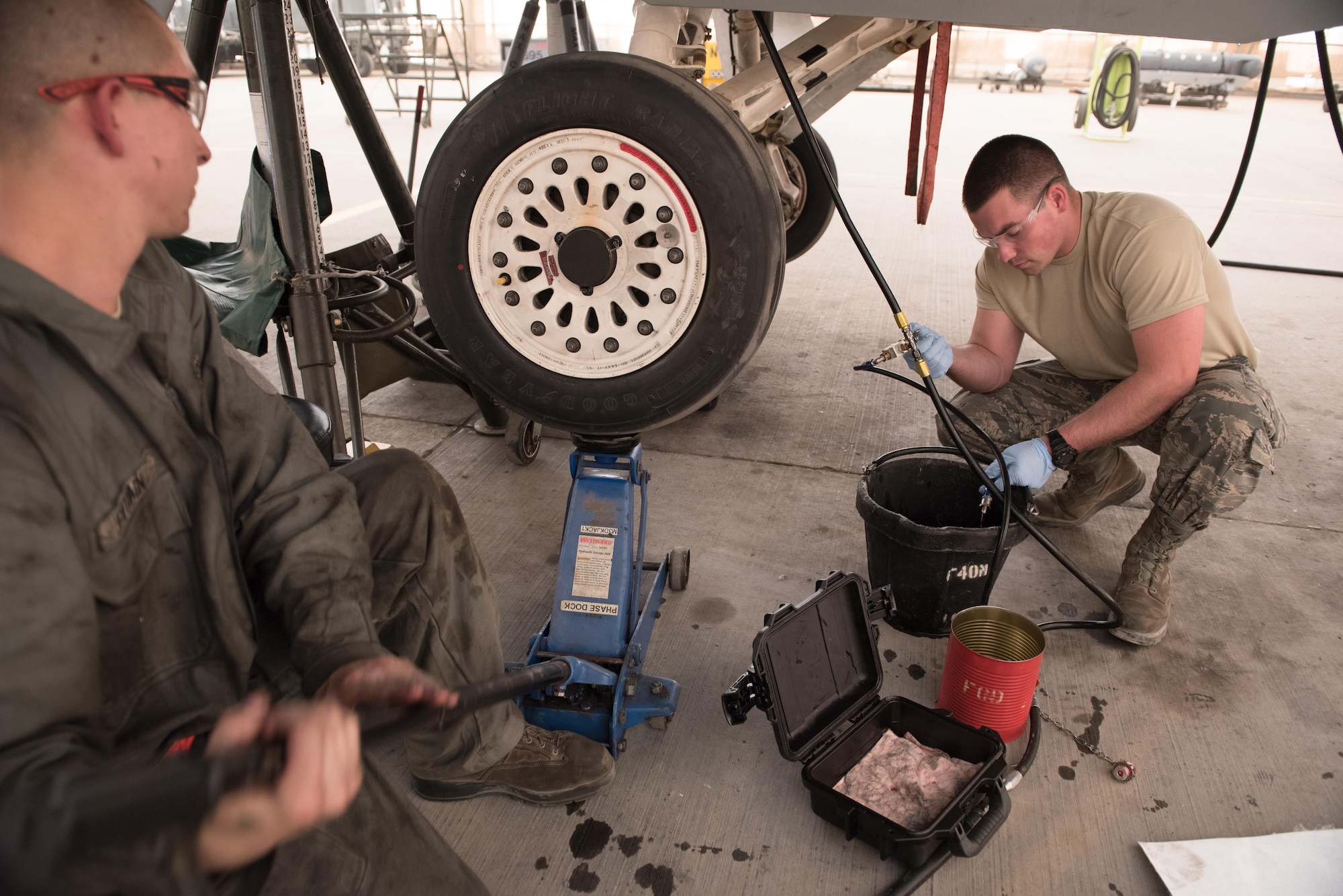 Senior Airman Sid Putvain, 407th Expeditionary Maintenance Squadron, jacks up the landing gear of an F-16 Fighting Falcon as Airman 1st Class Devon Sanborn, 407th EMXS, relieves pressure from a hydraulic line at the 407th Air Expeditionary Group, Dec. 25, 2016. The Airmen must service the jet on Christmas day to ensure it is ready to fly missions in support of Operation Inherent Resolve.  (U.S. Air Force photo/Master Sgt. Benjamin Wilson)(Released)