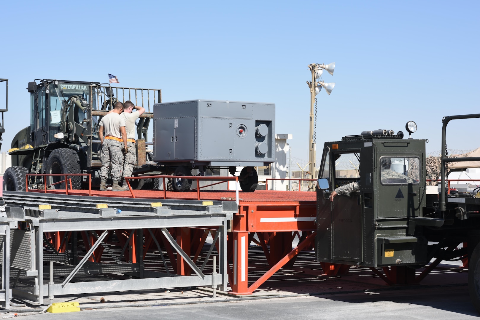 U.S. Air Force Airmen with the 8th Expeditionary Air Mobility Squadron load cargo onto a Tunner 60K cargo loader at Al Udeid Air Base, Qatar, Dec. 12, 2016. Airmen with the 8th EAMS work day and night at one of U.S. Central Command’s busiest en route station to ensure cargo and personnel get to their destinations. (U.S. Air Force photo by Senior Airman Cynthia A. Innocenti)