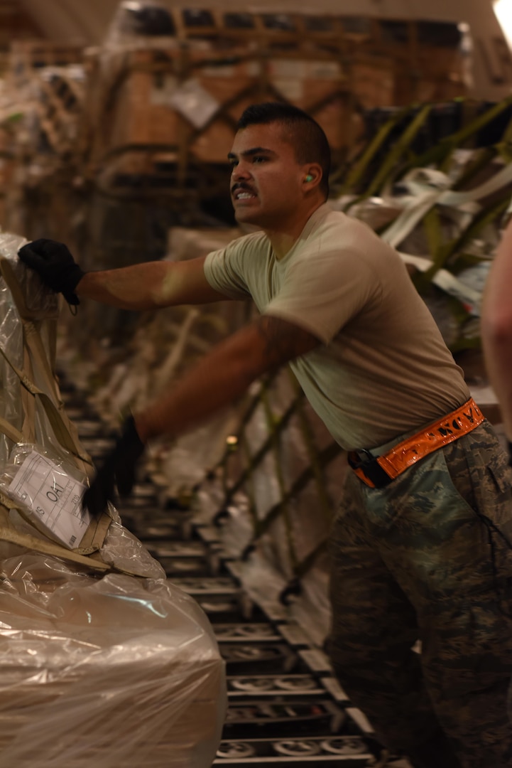 U.S. Air Force Senior Airman Zephaniah Valdez, a ramp services specialist with the 8th Expeditionary Air Mobility Squadron, assists moving cargo onto a Tunner 60K cargo loader at Al Udeid Air Base, Qatar, Dec. 24, 2016. The 8th EAMS expertise in transportation and logistics enable them to inspect, temporarily store and load cargo such as munitions, blood, special operations cargo, hazardous materials, vehicles and medical supplies. (U.S. Air Force photo by Senior Airman Cynthia A. Innocenti)